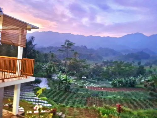 uma vista da varanda de uma casa com montanhas ao fundo em Villa Bumisoka em Purwakarta