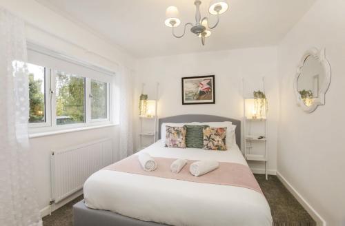 - une chambre blanche avec un lit et 2 serviettes dans l'établissement The Willows, à York