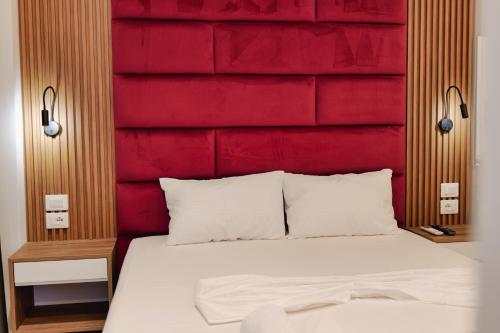 a bedroom with a red headboard and a white bed at Vila Shpetimi in Ksamil