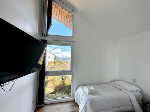 a bedroom with a bed and a large window at Starigrad in Ushuaia
