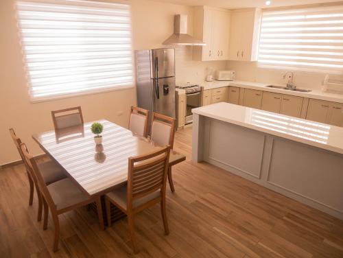 a kitchen with a white table and chairs and a table and a kitchen with at Las Casitas en Miraflores Guayaquil in Guayaquil