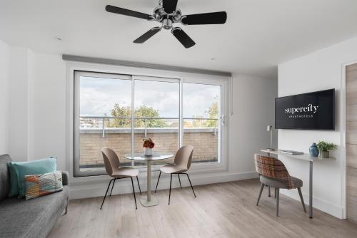 a living room with a table and chairs and a window at Q Square by Supercity Aparthotels in Brighton & Hove
