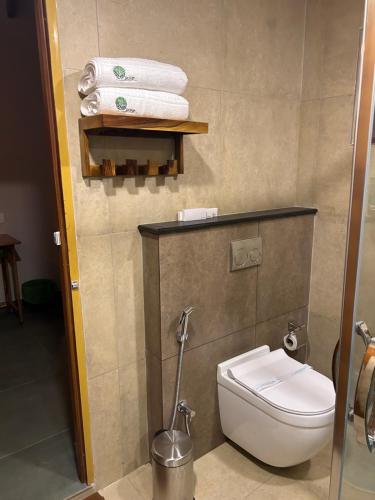 a bathroom with a toilet and some towels at SylVan Resort in Wayanad