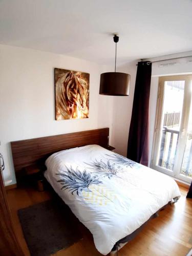 une chambre avec un lit et un tableau au mur dans l'établissement Deauville vue mer rue des villas, à Deauville