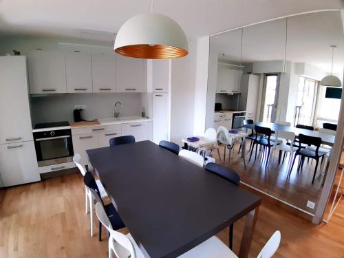 une cuisine et une salle à manger avec une table et des chaises noires dans l'établissement Deauville vue mer rue des villas, à Deauville