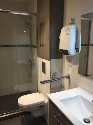 une salle de bain avec toilettes, lavabo et douche dans l'établissement Deauville vue mer rue des villas, à Deauville