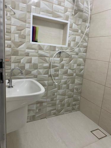 a bathroom with a sink and a shower with a mirror at Casa da vovó Marta in Itanhaém