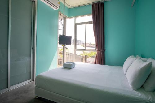 een slaapkamer met een groot wit bed en een raam bij HeyHa House in Chiang Mai