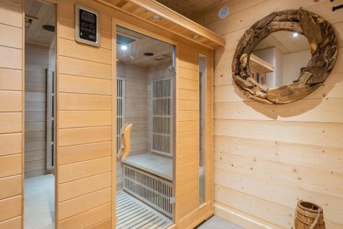 a sauna with a mirror on the wall at Chalet Frantz'y in Saint-Jean-d'Aulps
