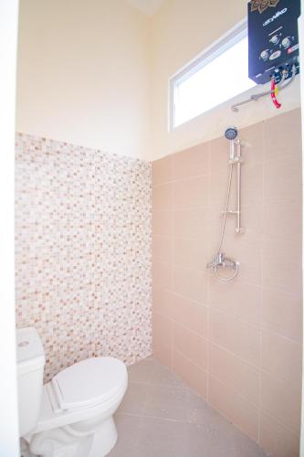 a bathroom with a toilet and a window at Villa Mulyo E4 by Sans Villa in Batu