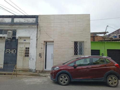 a red car parked in front of a building at Casa no coração de Recife para Carnaval in Recife