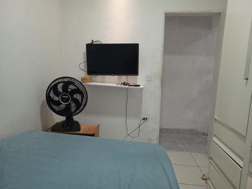 a bedroom with a bed and a tv and a fan at Casa no coração de Recife para Carnaval in Recife