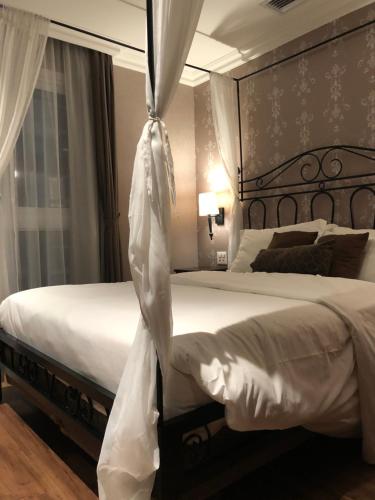 a bedroom with a large bed with white sheets at Buona Vitta Gramado Resort Spa in Gramado