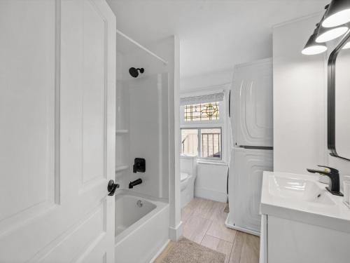 Baño blanco con bañera y lavamanos en Shadyside, Pittsburgh, Modern and Stylish 1 Bedroom Unit5 with Free Parking, en Pittsburgh