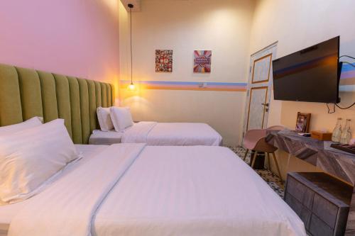 Cette chambre comprend 2 lits et une télévision à écran plat. dans l'établissement BELVA huis, à Bogor