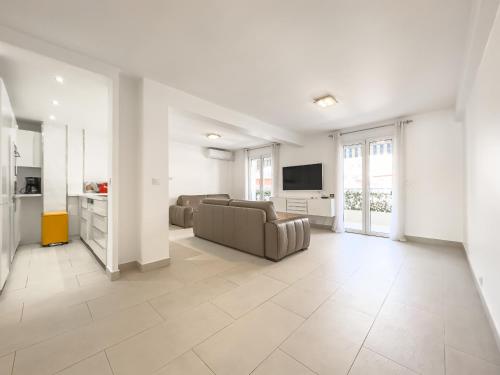 un grand salon avec un canapé et une télévision dans l'établissement Le Maubourg by Winsome Destination, à Cannes