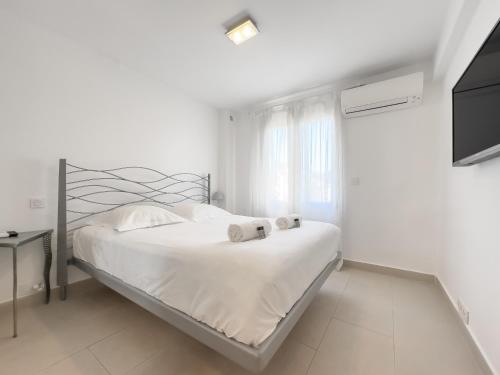 une chambre blanche avec un lit et une télévision dans l'établissement Le Maubourg by Winsome Destination, à Cannes
