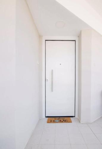 a large white door in a room with a tile floor at Seascape Serenade in Oropós