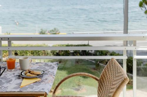 a table with a plate of food on a balcony with the ocean at Seascape Serenade in Oropós