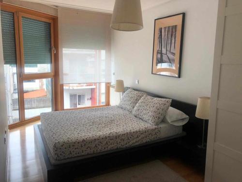 een slaapkamer met een bed en een raam bij Apartamento en Santoña in Santoña
