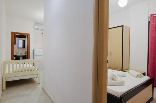 a small bedroom with a bed and a mirror at Vila Shpetimi in Ksamil