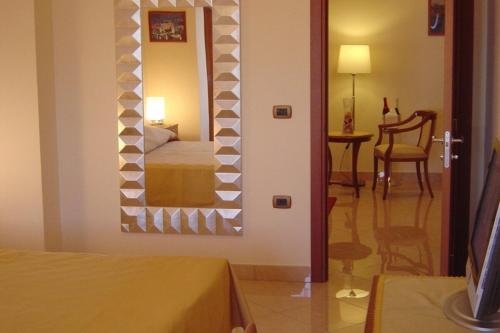 una camera da letto con un letto e uno specchio a parete di Ranch Palace Hotel a Napoli