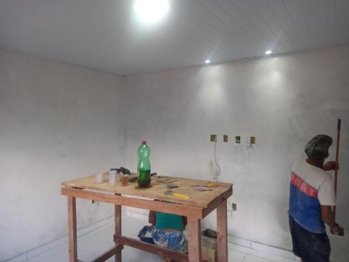 un hombre de pie junto a una mesa en una habitación en Casa para alugar ano novo, en Itacaré