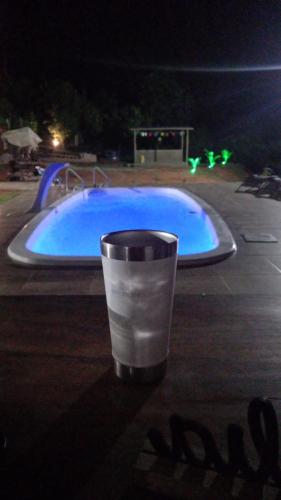 a cup in front of a swimming pool at night at Casa para alugar ano novo in Itacaré