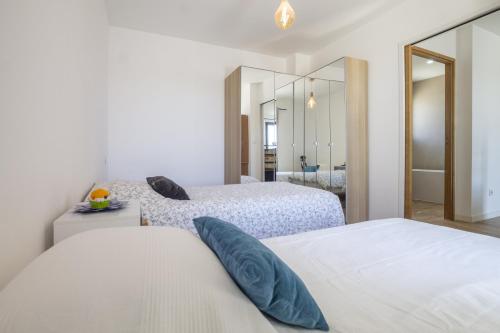 Un dormitorio con dos camas y un espejo. en Maison des Fleurs, en Vedène