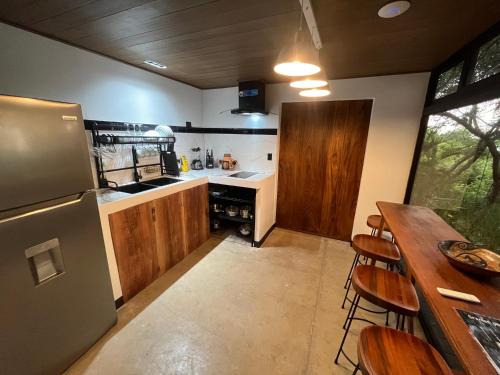 a kitchen with a refrigerator and a table with chairs at Sweet Jungle Beach in Bejuco