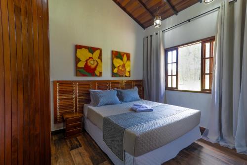 1 dormitorio con cama y ventana en Art Green Teresópolis en Teresópolis