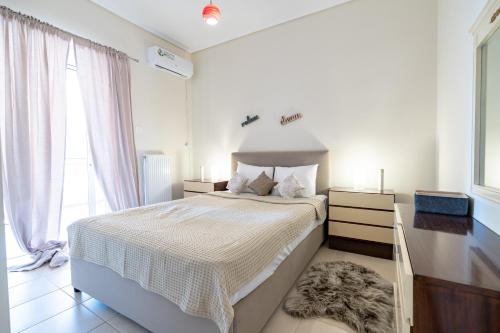 um quarto com uma cama grande com lençóis brancos e uma janela em Koropi 3 bedroom Luxurious Apartment 5 pers- Angel House em Koropíon