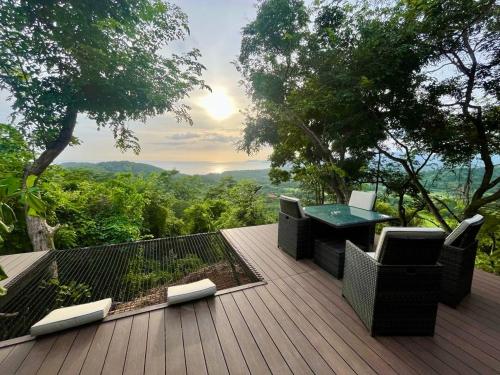 a wooden deck with a table and chairs on it at Sweet Jungle Beach in Bejuco