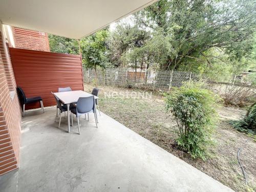 eine Terrasse mit einem Tisch, Stühlen und einem Zaun in der Unterkunft 2950-Appartement 4 pers avec piscine in Argelès-sur-Mer