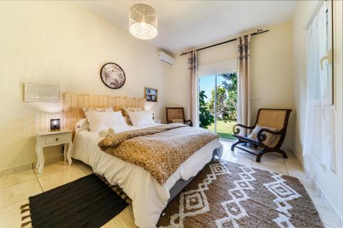 a bedroom with a bed and a clock on the wall at Villa et grand jacuzzi six personnes visite à la ferme in Saint-Joseph