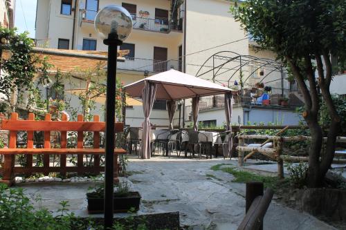 a street light next to a patio with a umbrella at Le Coeur du Pont in Donnas