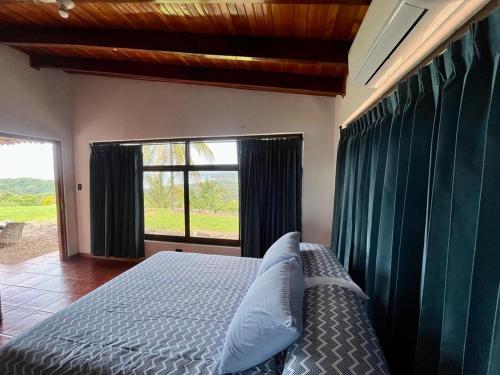 a bedroom with a bed and a large window at Sweet Jungle Beach in Bejuco