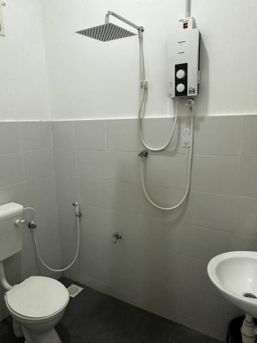 a bathroom with a shower and a toilet and a sink at Aisy Guest House - MUSLlM Only in Kangar