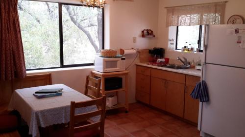 a kitchen with a table and a white refrigerator at Desert Trails Bed & Breakfast in Tucson