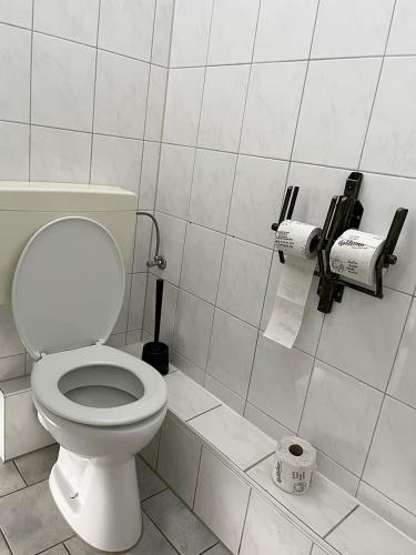 a bathroom with a toilet and two rolls of toilet paper at Homeplanet Hostel in Leipzig