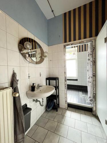 a bathroom with a sink and a shower at Homeplanet Hostel in Leipzig