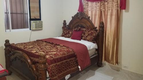 un lit avec un cadre en bois dans une chambre dans l'établissement Apartamentos JuanSabeloTodo, à Santiago de los Caballeros