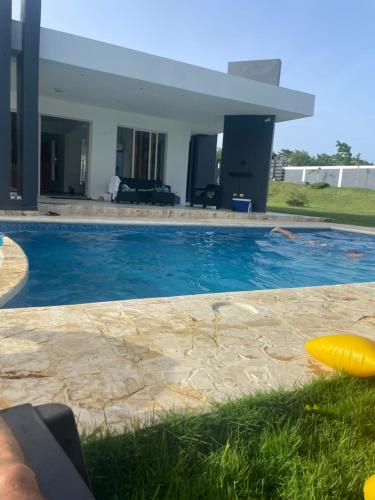 a swimming pool with a yellow frisbee in front of a house at Villa Sol House 