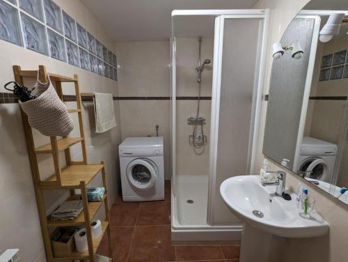 a bathroom with a sink and a washing machine at La Paloma in Tarragona