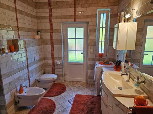 ein Badezimmer mit einem Waschbecken, einem WC und einem Waschbecken in der Unterkunft apartment AURORA in Rogaška Slatina