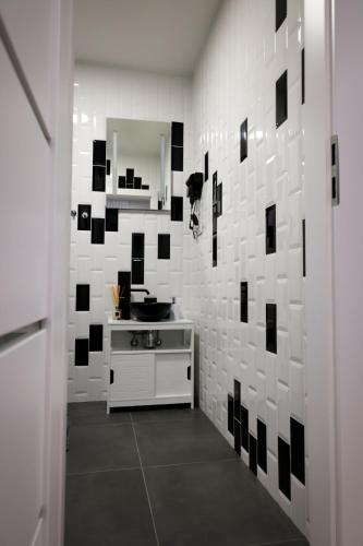 a bathroom with black and white tile on the wall at Romantic Room Šiauliai in Šiauliai