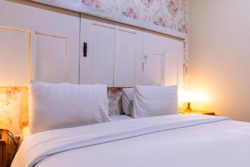 a bedroom with a large white bed with white pillows at BELVA huis in Bogor