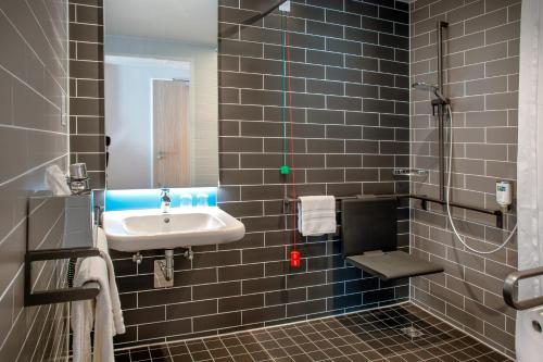 uma casa de banho com um lavatório e um chuveiro em Holiday Inn Express Karlsruhe - City Park, an IHG Hotel em Karlsruhe