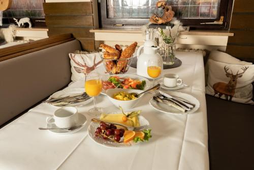 un tavolo con colazione a base di cibi e succo d'arancia di Gasthaus Schneider a Bad Bocklet
