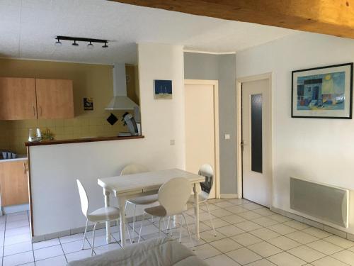 une cuisine et une salle à manger avec une table et des chaises dans l'établissement Appartement T1Bis dans un mas, à Port-Vendres